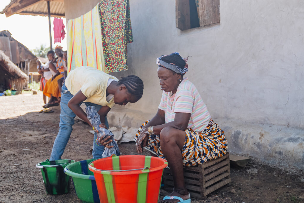 baindu, orthopedics patient, helping her grandmother with laundry
